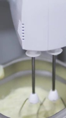 Şekerlemeler, pişirme ve pişirme konsepti. Evdeki mutfakta pasta yapan kadın. Bento keki yapma süreci. Elinde kremalı ahudududulu kek tutan kadın.