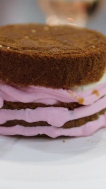 Şekerlemeler, pişirme ve pişirme konsepti. Evdeki mutfakta pasta yapan kadın. Bento keki yapma süreci. Elinde kremalı ahudududulu kek tutan kadın.