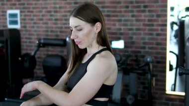 Spor salonundaki aynada yansımasına bakan çekici bir kadın. Spor salonundaki kız gülümsemesi