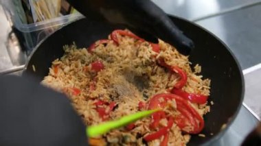 Paella geleneksel İspanyol yemekleri. İnsan kızartma tavasından tabağa deniz mahsulü paella koyar. Midyeli paella, Kral karidesleri, langoustine ve mürekkep balıklarıyla. Paella pişiren kişi. Akşam yemeği. 4K