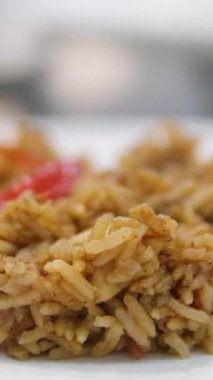 Paella geleneksel İspanyol yemekleri. İnsan kızartma tavasından tabağa deniz mahsulü paella koyar. Midyeli paella, Kral karidesleri, langoustine ve mürekkep balıklarıyla. Paella pişiren kişi. Akşam yemeği. 4K