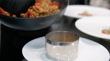 Paella geleneksel İspanyol yemekleri. İnsan kızartma tavasından tabağa deniz mahsulü paella koyar. Midyeli paella, Kral karidesleri, langoustine ve mürekkep balıklarıyla. Paella pişiren kişi. Akşam yemeği. 4K