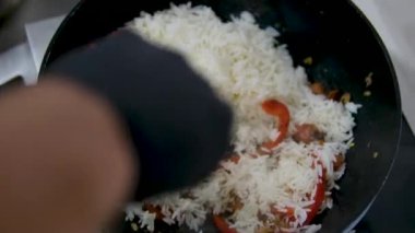Paella geleneksel İspanyol yemekleri. İnsan kızartma tavasından tabağa deniz mahsulü paella koyar. Midyeli paella, Kral karidesleri, langoustine ve mürekkep balıklarıyla. Paella pişiren kişi. Akşam yemeği. 4K