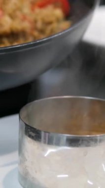 Paella geleneksel İspanyol yemekleri. İnsan kızartma tavasından tabağa deniz mahsulü paella koyar. Midyeli paella, Kral karidesleri, langoustine ve mürekkep balıklarıyla. Paella pişiren kişi. Akşam yemeği. 4K