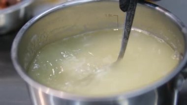 Pirinç pişiriyorum. Ahşap bir kaşık kaynar suda pirinci karıştırır. Yemek hazırlama. Tarifi görselleştirmek için bir dizi görüntü. Tencerede pilav pişir.