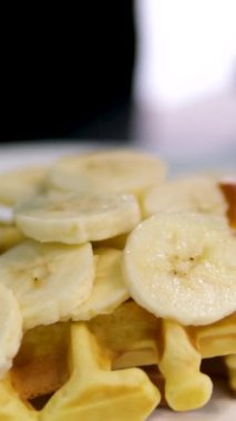 Beyaz üzerine muz, krema ve karamel soslu lezzetli Belçika waffleları.