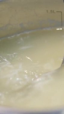 Pirinç pişiriyorum. Ahşap bir kaşık kaynar suda pirinci karıştırır. Yemek hazırlama. Tarifi görselleştirmek için bir dizi görüntü. Tencerede pilav pişir.