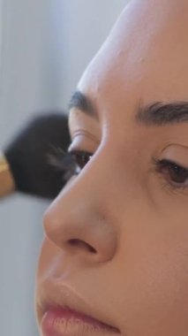 Güzel bir kızın portresi, makyaj sanatçısı genç bir manken, stüdyo çekimi, moda fotoğrafçılığı, güzellik salonu için makyaj yapıyor. Kız makyaj salonu