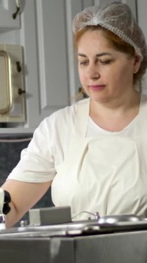 Taze işlenmiş süt ürünlerini paketleyen ve bunları ihracat için etiketleyen işçiler, kaliteyi ve uluslararası standartlara uymayı sağlıyorlar. Kadın süt ürünleri hazırlıyor