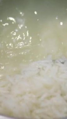 Kadın ellerinin klozette kevgir pilavı yıkadığı yakın plan.