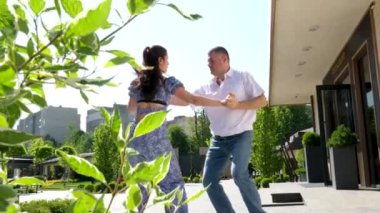 Klasik halk mekanında dans eden karışık ırk çifti. İnsanlar açık kafede salsa ve bachata yapıyor.