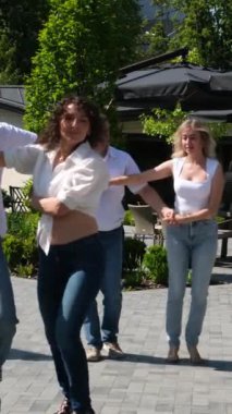 Klasik halk mekanında dans eden karışık ırk çifti. İnsanlar açık kafede salsa ve bachata yapıyor.