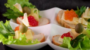 Yemek geçmişi. Kırmızı havyarlı birkaç sandviç bir tabakta döner. Yakın plan. Havyarlı sandviç.