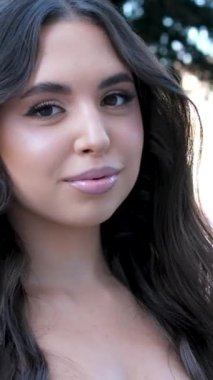 Doğadaki genç seksi esmer kızın portresini yakından çek. Kazak genç kadın bahar sabahını ve kışı saçlarında, seçilmiş odak noktasında geçirir..