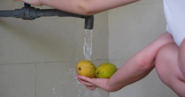 Mango, taze meyve yıkama, sebzeli yıkama. Akan suyun altında meyve yıka Mango