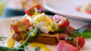 Ekmek ve domatesli Benedict usulü yumurta ve Becon Morning sandviçi. Hollandaise soslu yumurta ve kızarmış somon.