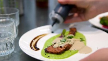 Soslu kırmızı balık eti hazırlama süreci. Kırmızı balıklı biftek. Balık yemeği. Restoran konsepti. Şef mutfakta somon bifteği pişiriyor.