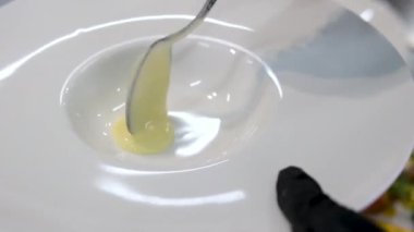 Beyaz arkaplandaki sığ bir tabaktaki beyaz bir tabaktaki erimiş tereyağlı sütlü yulaf lapası. Semolina lapası tabağı