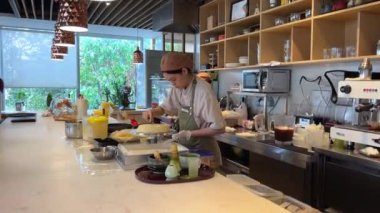 Kapalı alanda çikolatalı kekin üzerine tereyağı sıkarak krema katmanı sıkıyorum. Vietnam Ho Chi Minh Şehri 08.14.2024 'e yakın hamur işi torbasının lezzetli süslemeleri üzerine yayılıyor.