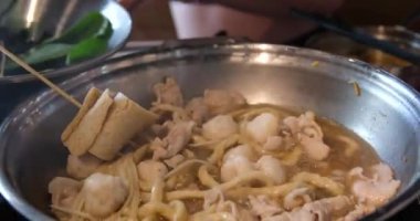 Sıcak bir mutfakta, modern bir indüksiyon sobasında, altında çorba kaynayan kaynayan bir tencerenin kapağı. Yapay zeka üretken