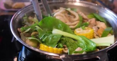 Sıcak bir mutfakta, modern bir indüksiyon sobasında, altında çorba kaynayan kaynayan bir tencerenin kapağı. Yapay zeka üretken