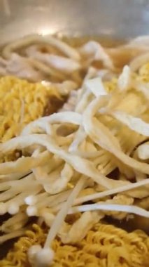 Sıcak bir mutfakta, modern bir indüksiyon sobasında, altında çorba kaynayan kaynayan bir tencerenin kapağı. Yapay zeka üretken