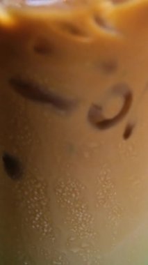 Barın arka planında nane şekeriyle süslenmiş yakın plan kahve bardağı. Buzlu kahveyi bardakta nane şurubuyla karıştır. Naneli kahve.