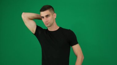 Yeşil arka plan kromakey yakın plan koyu saçlı yakışıklı adamın seksi pazılı duyguları. Genç adam. Spor salonundaki kaslı adam kaslarını gösteriyor. Güçlü erkek.