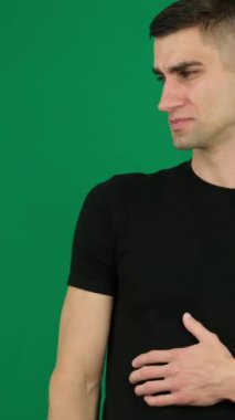 Korku, tatsız duygular, arkanızı dönün, sapın, ellerinizle kendinizi koruyun. Yeşil arka plan krom renkli, yakın plan koyu saçlı yakışıklı bir adamın duyguları. Genç adam.
