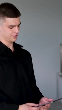 Gülümseyen genç Hintli iş adamı profesyonel, doğulu iş adamı sokak ortasında kitap okuyan yönetici elinde dijital tablet kullanarak gece şehrinde duruyor. Erkek tableti