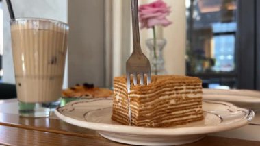 Altın çatallı beyaz bisküvi yiyorum. Beyaz kremalı ballı kek. Şekerleme konsepti. Ballı kek.