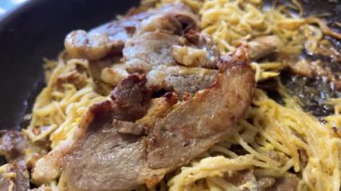 Kızarmış vermicelli 'nin servis edilmeye hazır bir tabağa konduğu yakın çekim. Eti tavada vermicelli ile ısıt.
