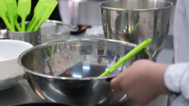 Bej önlüklü güzel kadın şef öğretmen çevrimiçi video konferans dizüstü bilgisayarı öğretiyor, ev hanımı öğrencilere ev kameralarına salata yapımında kullanılan malzemeleri gösterdiğini söylüyor.