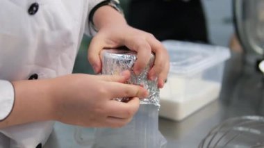 Yemek pişirme, pişirme ve pişirme konsepti. Pasta pişiren ve evdeki mutfakta pişirme kabına hamuru koyan genç kadın. Ev yapımı folyo kalıbı