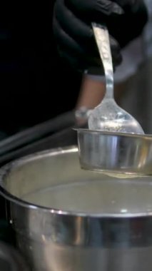 Limon kabuğuyla doldurulmuş alkolü süzer ve süzer. Ana, şeker şurubuyla karıştırmak için gereken sıvı hacmini ölçer. Krema süzgecinden geçerek yaşa. Turunçgiller süt altında soyulur.