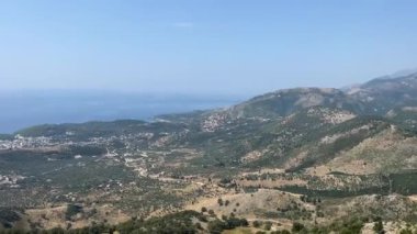 Dağ yamacında ormanlı beyaz kayaya karşı. Gün batımında dağlardaki gözlem güvertesinin havadan görüntüsü. İnsansız hava aracı videosu. Arnavutluk.