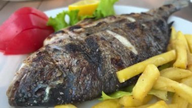 Kızarmış sebzeli Dorado balığı ve patates kızartması.
