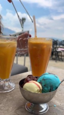 Arnavutluk 'un yazlık kafesinde Gerakastra' da taze sıkılmış iki meyve suyu çok renkli dondurma