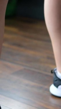 Spor salonunda kettlebell ile egzersiz yapan atletik kadınların yakın çekimi. Kadın bacakları ağırlık kaldırıyor.