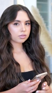 Kız cep telefonuyla oturur, kamerayı görür ve gider.