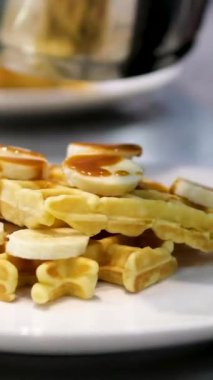 Koyu çikolata ve karamel soslu gözleme. Waffle 'ın üzerine karamel serpiştir. muz dilimleri