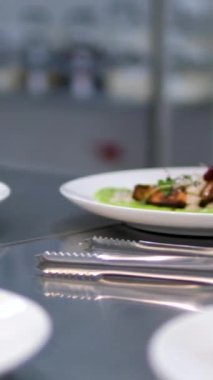 Bir restoran şefinin sahne arkasına dekore edilmiş, yemek hazırlayan bir restoranın eşit porsiyonlarında, madalyonlara kızarmış et pişirmek. bölümlendirilmiş