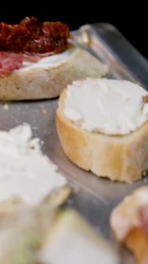 Açık büfe için jambonlu jambonlu ve peynirli bruschetta ekmekli bir sandviçin üzerine güneşte kurutulmuş domates koy. Türkiye Sandviçi