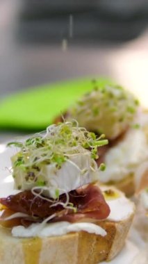 Restorandaki mutfakta yeşillikle dekore et. Peynirli ve jambonlu açık büfe sandviçler için lezzetli atıştırmalıklar. Jambonlu sandviç üzerine sos dök.