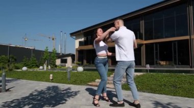 Genç ve çekici bir çiftin deniz kenarında Latince dans eden portresi. Okyanus sahilinde bir profesyonel dans gösterisi yapıyor. Siyah elbiseli bir kadın. Şehvetli salsa, rumba. Bachata dansı