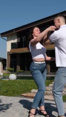 Genç ve çekici bir çiftin deniz kenarında Latince dans eden portresi. Okyanus sahilinde bir profesyonel dans gösterisi yapıyor. Siyah elbiseli bir kadın. Şehvetli salsa, rumba. Bachata dansı