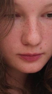 Kafede oturan genç ve güzel bir kız. Yürüyen insanların geçmişine bakarak telefon ekranına bakıyor.