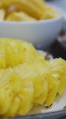 Doğranmış ananas salatası taze, lezzetli ananas dilimlenmiş. Lezzetli bir yaz ananası dilimlenmiş meyve tatlısı. Mutfak masasında yemek pişirme sürecinde malzemeler var..