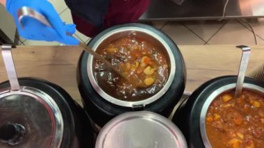 Romen mutfağının farklı türde tencere kepçesinde farklı türde çorbaları, tabaklara serpiştirilmiş kepçeyle lezzetli aromatik yemekler, farklı tarifler, yemek odasında geniş bir yelpazede seçiliyor. Romanya.