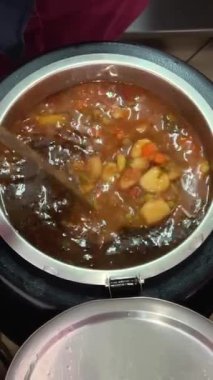 Romen mutfağının farklı türde tencere kepçesinde farklı türde çorbaları, tabaklara serpiştirilmiş kepçeyle lezzetli aromatik yemekler, farklı tarifler, yemek odasında geniş bir yelpazede seçiliyor. Romanya.